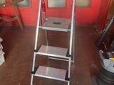 a ladder that is sitting in front of a red door