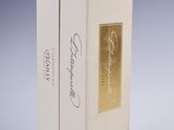 pair of white boxes with gold foil on them sitting on a table