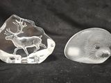 une paire de figurines d'animaux en verre transparent sur fond noir