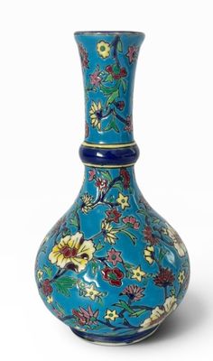 un vase bleu avec des fleurs sur un fond blanc