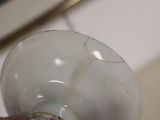 a person holding a white light bulb with a brown spot on it