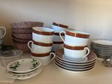 many cups and saucers sitting on a table