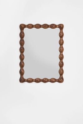 un miroir en bois avec un cadre en corde, accroché au mur