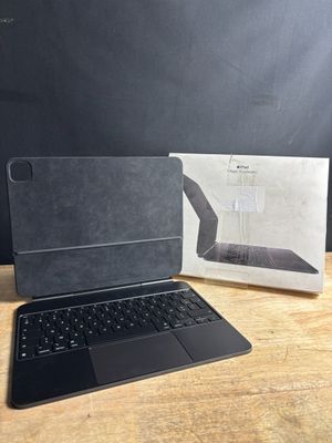 an open laptop sitting on top of a wooden table next to a box