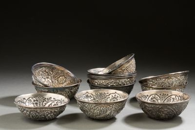 several silver bowls and spoons are lined up on a table