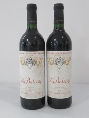 two bottles of red wine sitting next to each other on a table