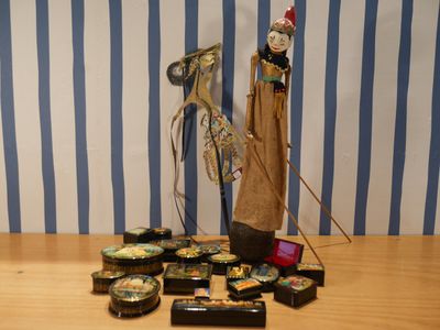 une statue représentant un homme debout à côté d'un tas d'objets posés sur une table