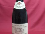 bottle of red wine on a red tablecloth with a pink background