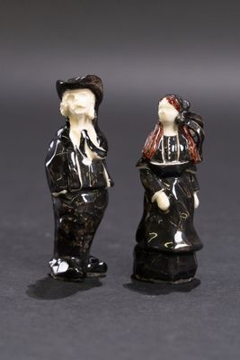 deux figurines d'un homme et d'une femme debout l'un à côté de l'autre