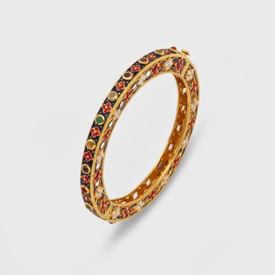 un gros plan sur un pendentif en or orné de pierres multicolores