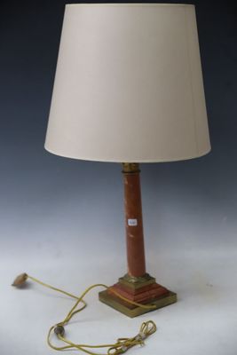 une lampe posée sur une table blanche, surmontée d'un abat-jour beige