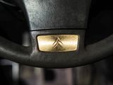 the steering wheel of a car with a gold emblem on it