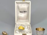 une image représentant une tasse et une cuillère en argent posées l'une à côté de l'autre