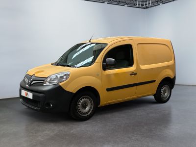 La camionnette jaune est garée dans une grande pièce aux murs blancs.