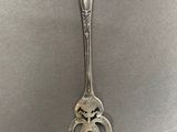 a fork with a face on it sitting on a table