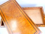 une boîte en bois munie d'un couvercle, dans laquelle se trouve un livre