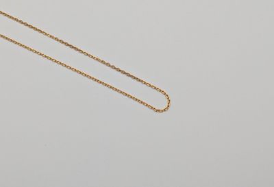 un collier à chaîne en or orné d'un petit diamant