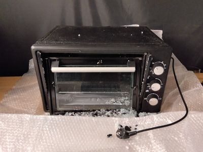 un four grille-pain cassé posé sur un morceau de plastique