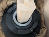 a wooden object in a box with a black handle