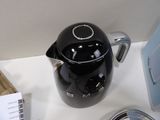 a black coffee pot sitting on a counter next to a blender