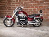 a red motorcycle that is parked in front of a brick wall