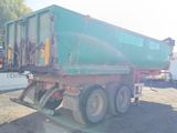 a green dump truck that is parked in a lot