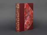 un vieux livre à la couverture rouge posé sur une table