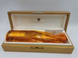 une image représentant un flacon de parfum dans un coffret, posé sur une surface blanche