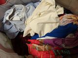 a basket full of clothes that is sitting on the floor