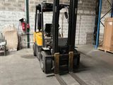 un chariot élévateur dans un entrepôt, avec des cartons et des palettes en arrière-plan