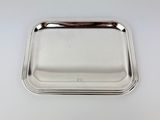 a silver tray on a white surface with a handle