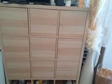 a tall wooden cabinet with a bunch of drawers in it