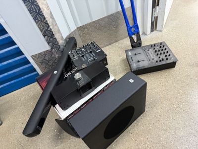 deux enceintes et une télécommande posées par terre, l'une à côté de l'autre