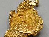 an image of a gold nugget is shown on a gray surface