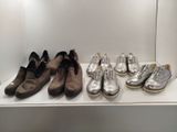 several pairs of shoes are lined up on a shelf in a display case