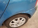 a blue car that has been dented and is parked in a garage