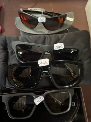 Plusieurs paires de lunettes de soleil sont exposées dans une vitrine.