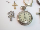 many different types of watches and crosses on the table