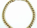gros plan d'un bracelet en chaîne en or sur fond blanc