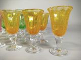 yellow glass goblets are lined up on a white table
