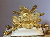 a gold clock with a bird on top of it