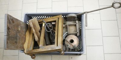une boîte remplie d'outils posée par terre dans une salle de bains