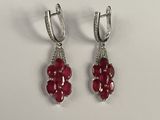 une paire de boucles d'oreilles en rubis et diamants sur fond blanc