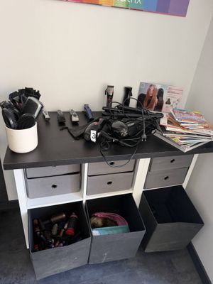 un bureau sur lequel sont posés plusieurs sèche-cheveux et d'autres objets