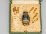 une petite boîte contenant un objet doré et noir