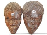 paire de masques africains en bois sculpté sur fond blanc