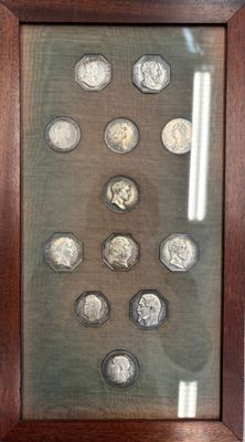 une image représentant une photo d'un présentoir de pièces de monnaie dans un cadre en bois