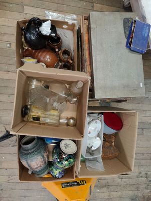une boîte remplie d'objets posée par terre dans une pièce
