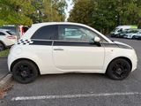 a small white car that is parked in a parking lot