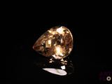 a close up of a yellow diamond on a black surface